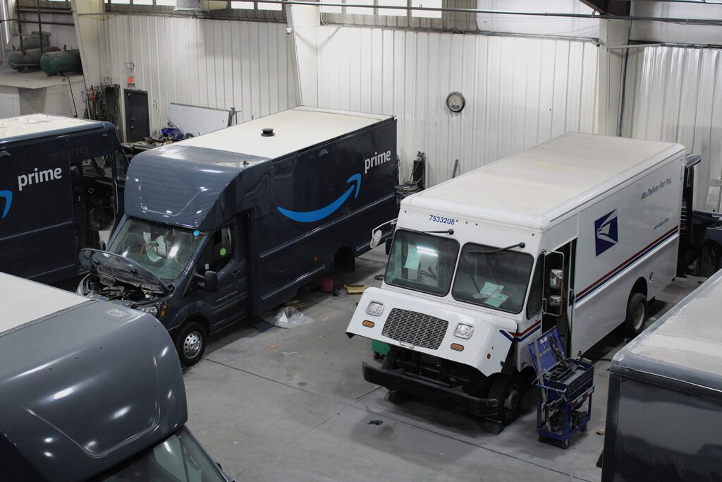 Amazon and USPS trucks in the 312 Truck Body Repair & Painting shop