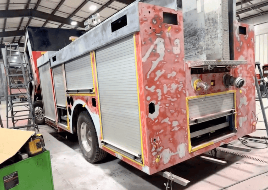 Morton Grove Fire Department Engine 5 undergoing professional fire truck body repair with compartments opened during the restoration process.